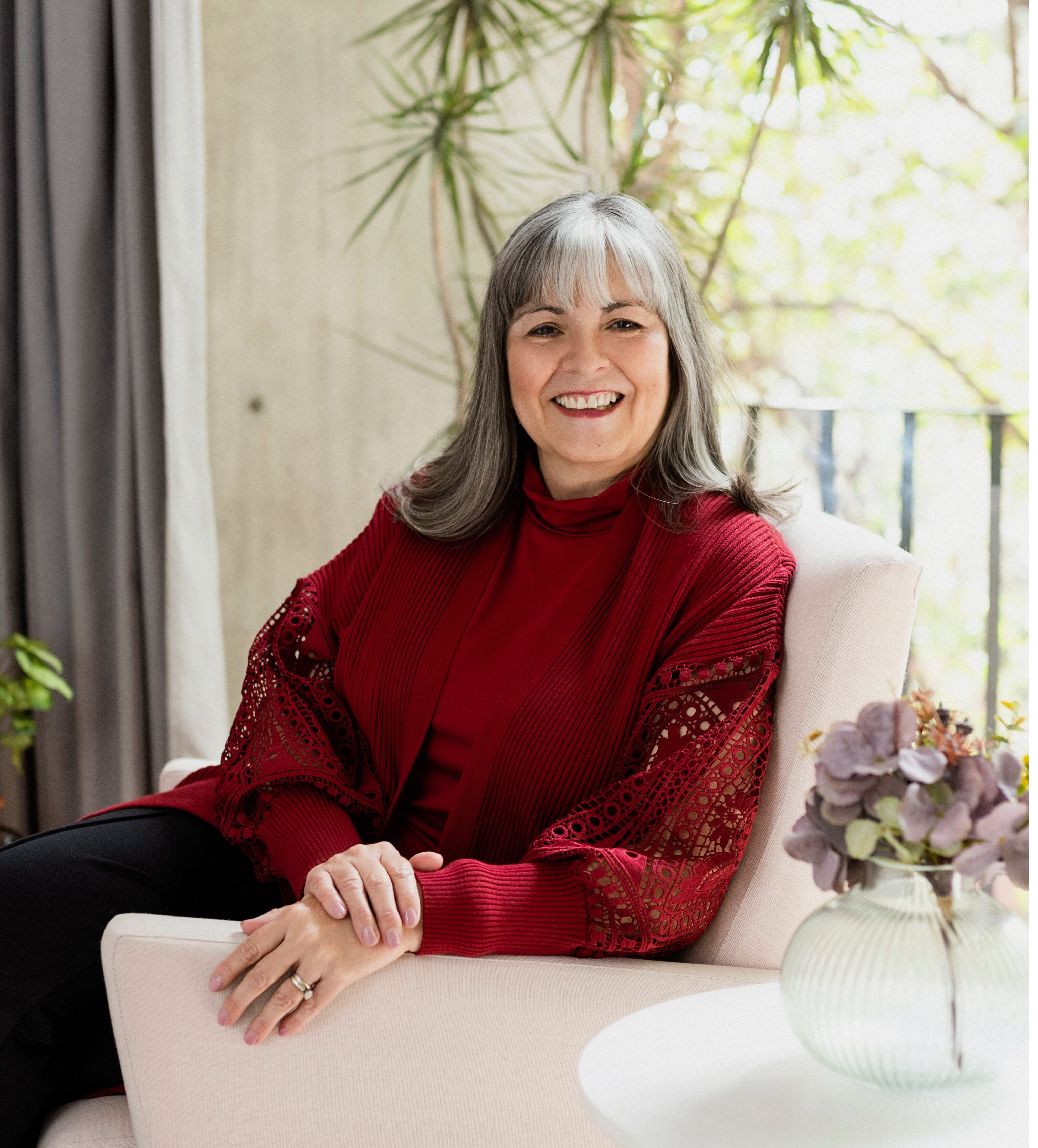 Analee McClellan, Principal, sitting in a chair smiling